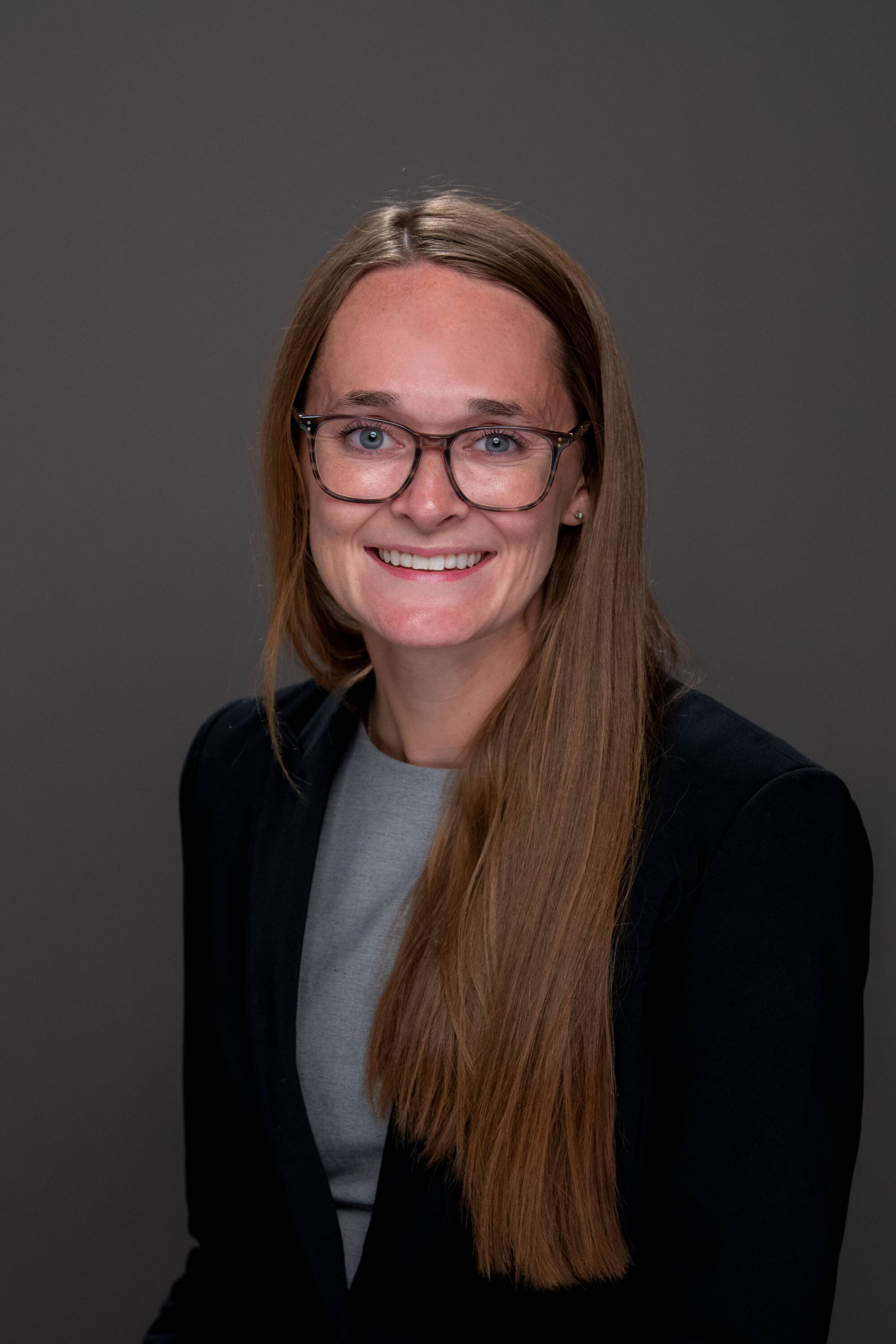 Emily Zeliasko wearing a gray shirt and black blazer